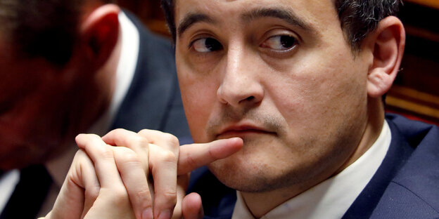 Minister Gérald Darmanin berührt mit dem Finer seine Lippen Minister Gérald Darmanin berührt mit dem Finer seine Lippen
