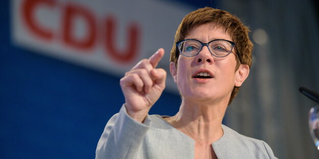 eine Frau zeigt mit dem rechten Zeigefinger nach vorne, im Hintergrund ein CDU-Logo eine Frau zeigt mit dem rechten Zeigefinger nach vorne, im Hintergrund ein CDU-Logo