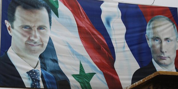 Ein Plakat mit den Gesichtern von Assad und Putin sowie der syrischen und der russischen Flagge Ein Plakat mit den Gesichtern von Assad und Putin sowie der syrischen und der russischen Flagge