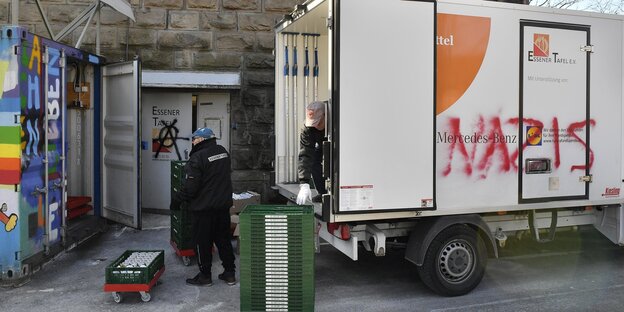 Helfer entladen einen Lkw, auf dem "Nazis" steht Helfer entladen einen Lkw, auf dem "Nazis" steht