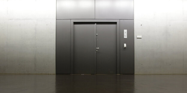 Eine in eine graue Wand eingelassene schwarze tür Eine in eine graue Wand eingelassene schwarze tür