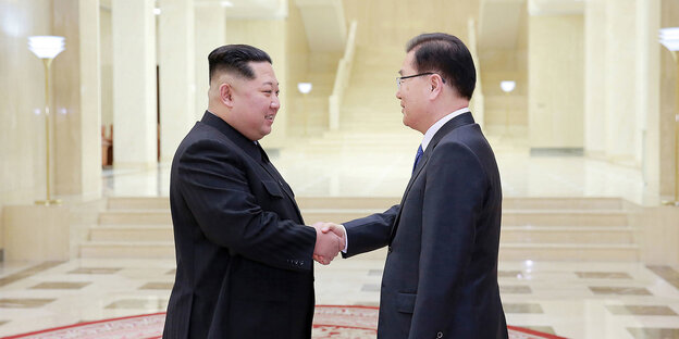 Kim Jong Un und ein nationaler Sicherheitsberater Südkoreas schütteln sich die Hand Kim Jong Un und ein nationaler Sicherheitsberater Südkoreas schütteln sich die Hand