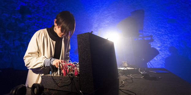 Babieri steht beim Elevate-Festival in einer blau beleuchteten Höhle am Mischpult.