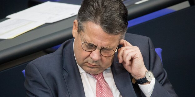 Sigmar Gabriel fasst sich ans Ohr und guckt dabei missmutig nach unten Sigmar Gabriel fasst sich ans Ohr und guckt dabei missmutig nach unten