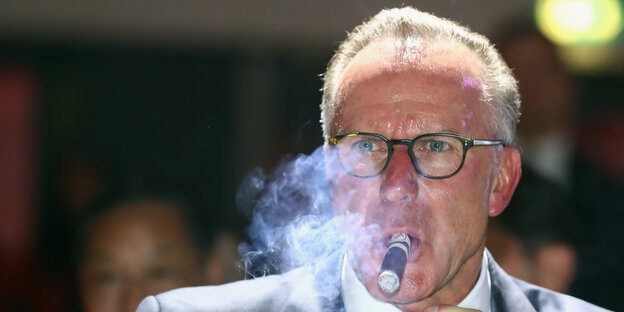 Bayern-Chef Karl-Heinz Rummenigge raucht eine Zigarre Bayern-Chef Karl-Heinz Rummenigge raucht eine Zigarre