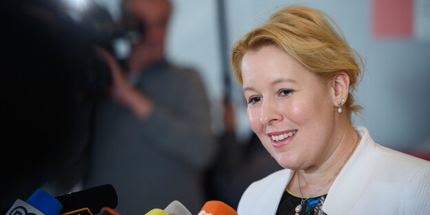 Franziska Giffey steht lächelnd vor Mikrofonen Franziska Giffey steht lächelnd vor Mikrofonen