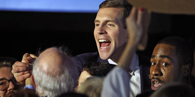 Der Demokrat Conor Lamb feiert inmitten von Anhängern. Der Demokrat Conor Lamb feiert inmitten von Anhängern.