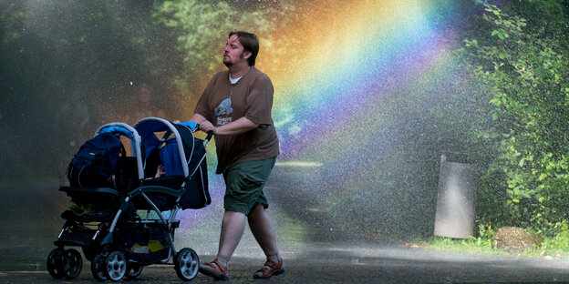 Mann mit Kinderwagen im Regenbogen Mann mit Kinderwagen im Regenbogen