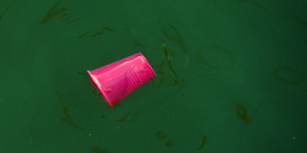 Roter Plastikbecher schwimmt im Hafenbecken Roter Plastikbecher schwimmt im Hafenbecken