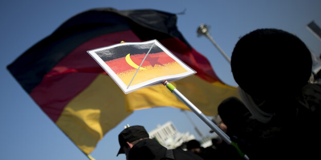 Schild mit Deutschlandfahne und durchgestrichenem Halbmond Schild mit Deutschlandfahne und durchgestrichenem Halbmond
