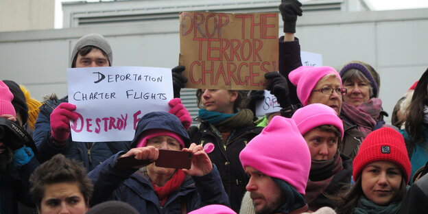 Männer und Frauen mit rosa Mützen und Proteschildern Männer und Frauen mit rosa Mützen und Proteschildern