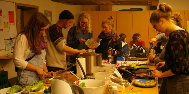 Gruppe junger Menschen kocht gemeinsam Gruppe junger Menschen kocht gemeinsam