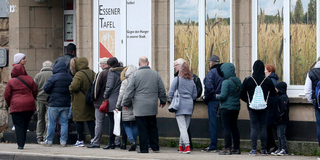 Menschen stehen vor einem Haus in einer Schlange