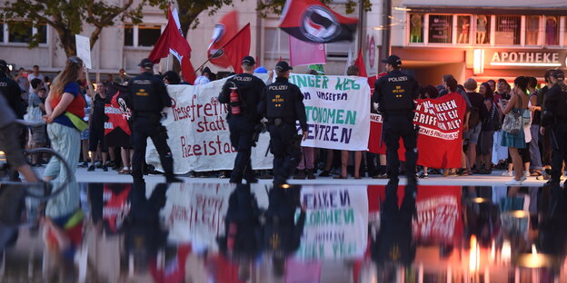 Viele Menschen mit Flaggen und Bannern, ihr Spiegelbild auf der Straße Viele Menschen mit Flaggen und Bannern, ihr Spiegelbild auf der Straße