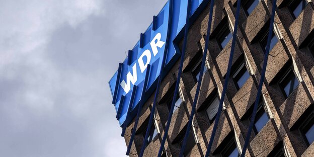 An einem Gebäude hängt ein WDR-Logo An einem Gebäude hängt ein WDR-Logo