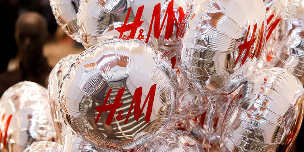Silberne Luftballons mit der roten Aufschrift „H&M“ Silberne Luftballons mit der roten Aufschrift „H&M“