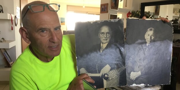 Ein Mann zeigt alte Fotos von einem Mann und einer Frau Ein Mann zeigt alte Fotos von einem Mann und einer Frau