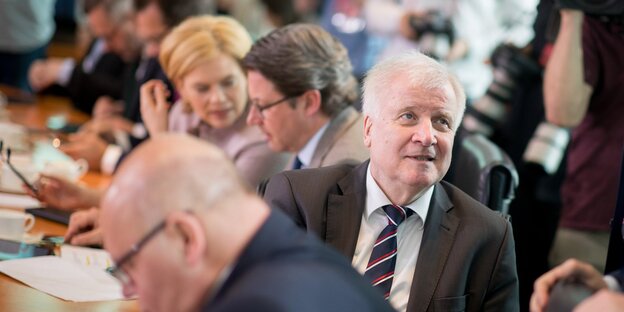 Horst Seehofer sitzt inmitten anderer Minister, dreht sich aber nach hinten aus der Reihe heraus Horst Seehofer sitzt inmitten anderer Minister, dreht sich aber nach hinten aus der Reihe heraus