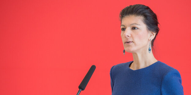 Eine Frau in blauem Kostüm hält eine Rede Eine Frau in blauem Kostüm hält eine Rede