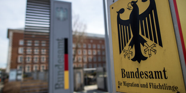 Ein Gebäude und davor ein Schild mit dem Bundesadler und der Aufschrift Bundesamt für Migration und Flüchtlinge Ein Gebäude und davor ein Schild mit dem Bundesadler und der Aufschrift Bundesamt für Migration und Flüchtlinge