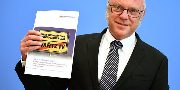 Ulrich Schneider zeigt Broschüre zu Hartz Ulrich Schneider zeigt Broschüre zu Hartz