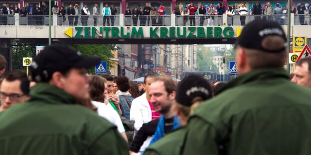 Viele Menschen auf der Straße, im Vordergrund zwei Polizisten Viele Menschen auf der Straße, im Vordergrund zwei Polizisten