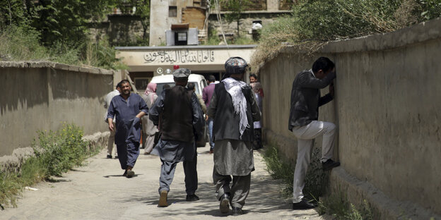 Ein Mann in Kabul weint gelehnt an eine Mauer über die Anschläge Ein Mann in Kabul weint gelehnt an eine Mauer über die Anschläge