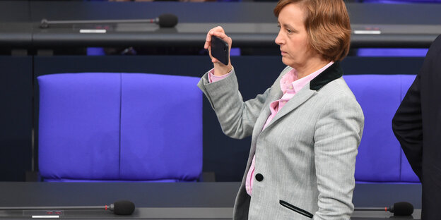 Beatrix von Storch steht im Bundestag und blickt auf ihr Handy Beatrix von Storch steht im Bundestag und blickt auf ihr Handy