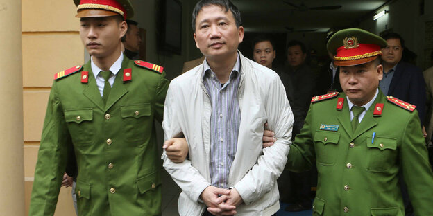 Trinh Xuan Thanh wird von zwei Uniformierten abgeführt Trinh Xuan Thanh wird von zwei Uniformierten abgeführt