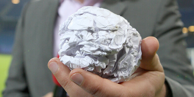 Eine Papierkugel in einer Hand Eine Papierkugel in einer Hand