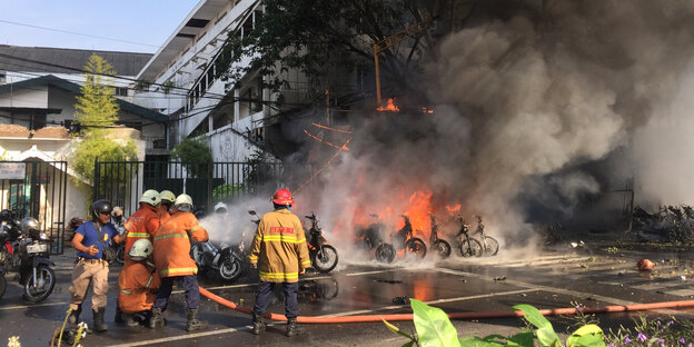 Feuerwehrleute stehtn vor einer stark rauchenden Brandstelle Feuerwehrleute stehtn vor einer stark rauchenden Brandstelle
