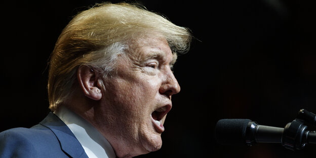 Trump im Profil, wie er in ein Mikrofon zu schreien scheint Trump im Profil, wie er in ein Mikrofon zu schreien scheint