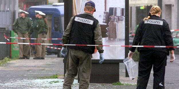 Polizisten vor Absperrbändern Polizisten vor Absperrbändern