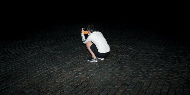 Ein junger Mensch fotografiert im Dunkeln Ein junger Mensch fotografiert im Dunkeln