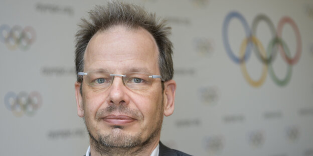 Hajo Seppelt, hinter ihm die olympischen Ringe Hajo Seppelt, hinter ihm die olympischen Ringe