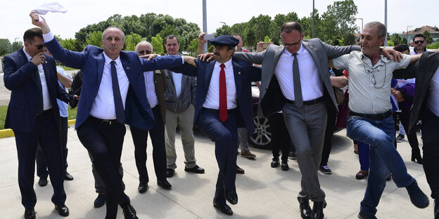 Muharrem Ince (l), tanzt bei einer Wahlkampfkundgebung mit Unterstützern zusammen und schwenkt ein Taschentuch