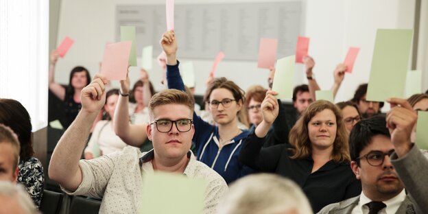 Besucher der Veranstaltung mit Stimmzetteln. Besucher der Veranstaltung mit Stimmzetteln.