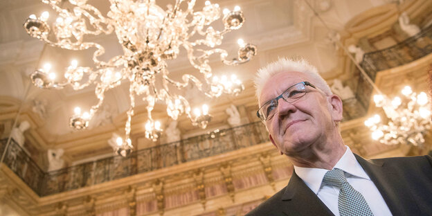Winfried Kretschmann von unten aufgenommen - gegen die Decke eines Festsaals mit Kronleuchter Winfried Kretschmann von unten aufgenommen - gegen die Decke eines Festsaals mit Kronleuchter