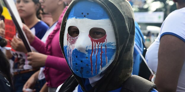Mensch mit blau weiß angemaltem Gesicht Mensch mit blau weiß angemaltem Gesicht