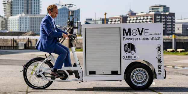 Ein Mann fährt ein Lastenfahrrad Ein Mann fährt ein Lastenfahrrad