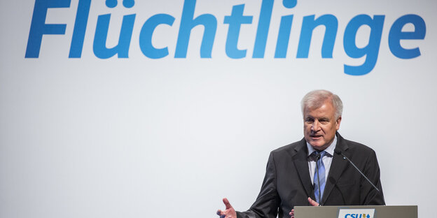 Innenminister Horst Seehofer stitzt unter dem Schriftzug "Flüchtlinge" Innenminister Horst Seehofer stitzt unter dem Schriftzug "Flüchtlinge"