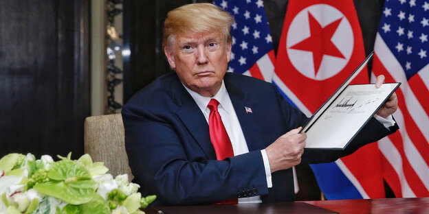Donald Trump hält eine Mappe hoch, in dem sich ein Dokument befindet Donald Trump hält eine Mappe hoch, in dem sich ein Dokument befindet