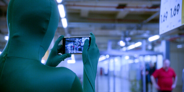 Person in Ganzkörpermaske fotografiert mit Handy Person in Ganzkörpermaske fotografiert mit Handy