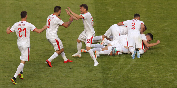 Serbische Spieler jubeln und liegen auf dem Rasen Serbische Spieler jubeln und liegen auf dem Rasen