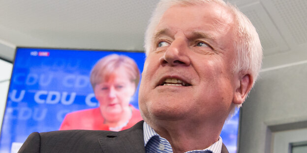 Älterer Mann vorn, Frau im Fernsehen hinten Älterer Mann vorn, Frau im Fernsehen hinten