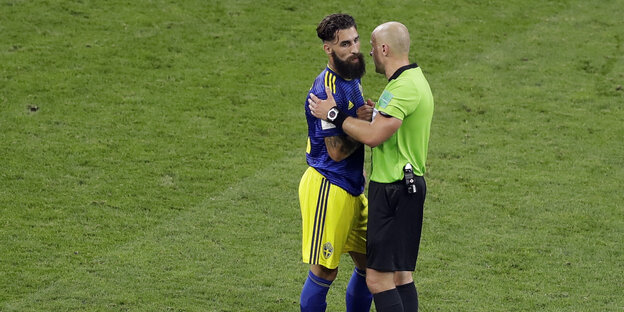 Schiedsrichter Szymon Marcniak spricht nach dem Spiel mit Jimmy Durmaz.