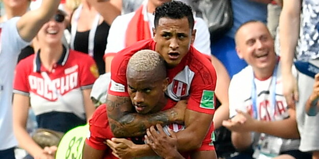 zwei Fußballer feiern ein Tor, im Hintergrund Zuschauer zwei Fußballer feiern ein Tor, im Hintergrund Zuschauer