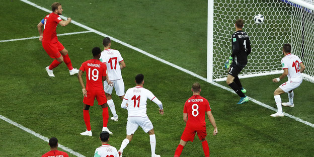 Harry Kane schießt einen Ball ins Tor, viele Spieler stehen drumherum Harry Kane schießt einen Ball ins Tor, viele Spieler stehen drumherum