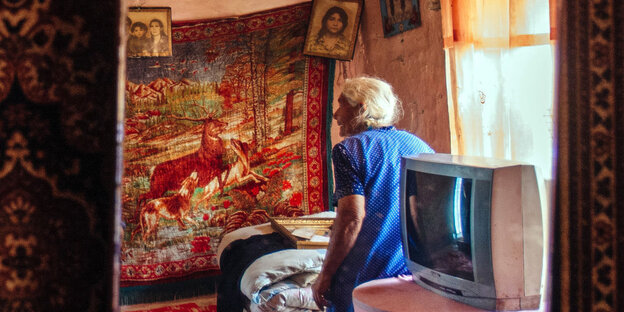 Eine ältere Frau steht im Schlafzimmer in einem Haus Eine ältere Frau steht im Schlafzimmer in einem Haus