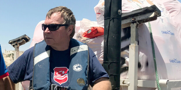 „Lifeline“-Kapitän Claus-Peter Reisch steht mit einer Rettungswesteam Wasser „Lifeline“-Kapitän Claus-Peter Reisch steht mit einer Rettungswesteam Wasser